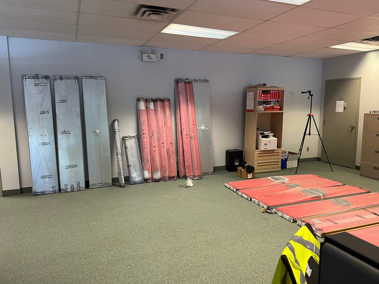 Quiet Cabins panels wrapped and stacked in an empty office before assembly