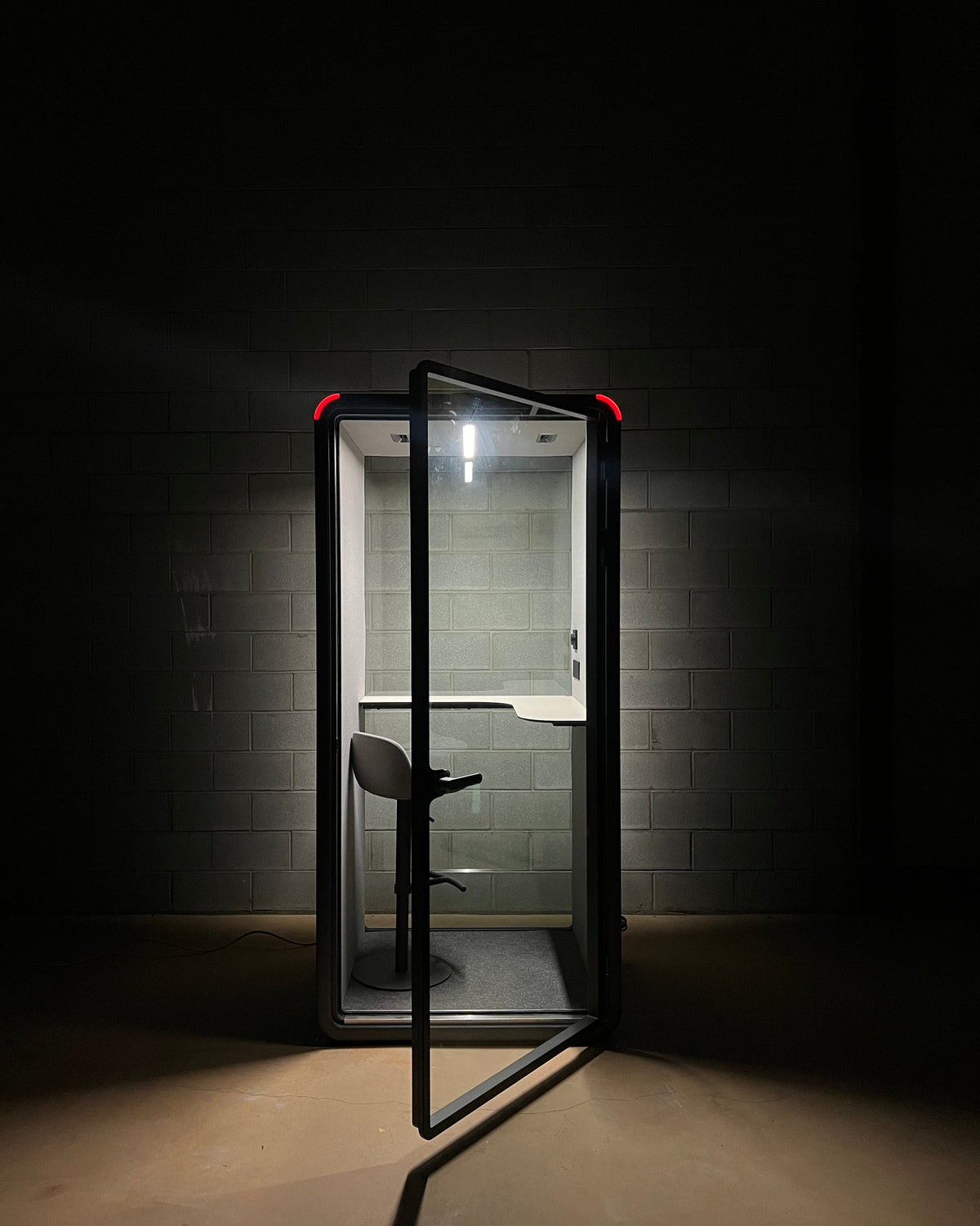 The occupancy light glowing red across a dark room. Anyone walking past can see the booth is in use ::detail