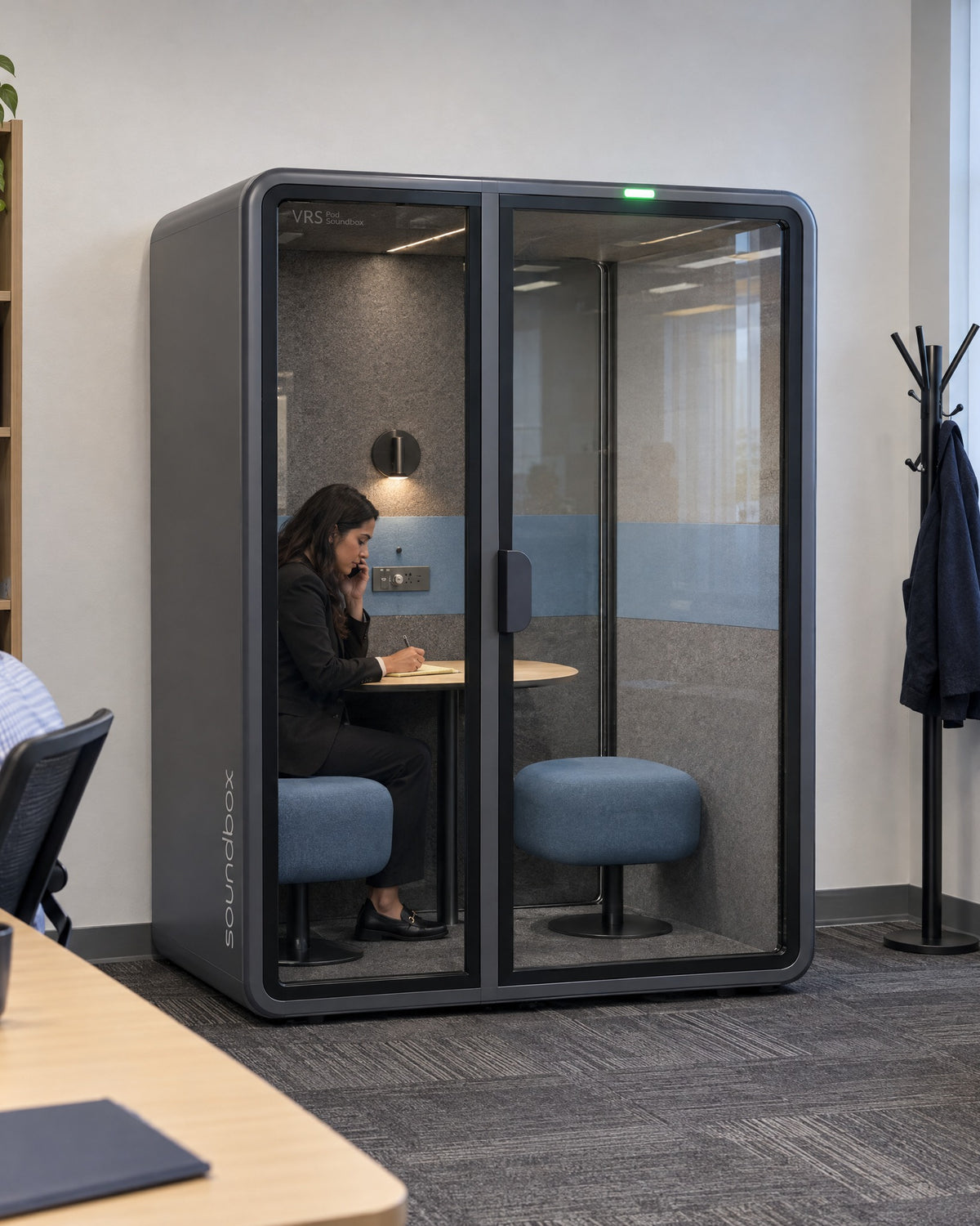 SoundBox VRS Comfort in a small law office, one person inside on a phone call taking notes. Illustration.