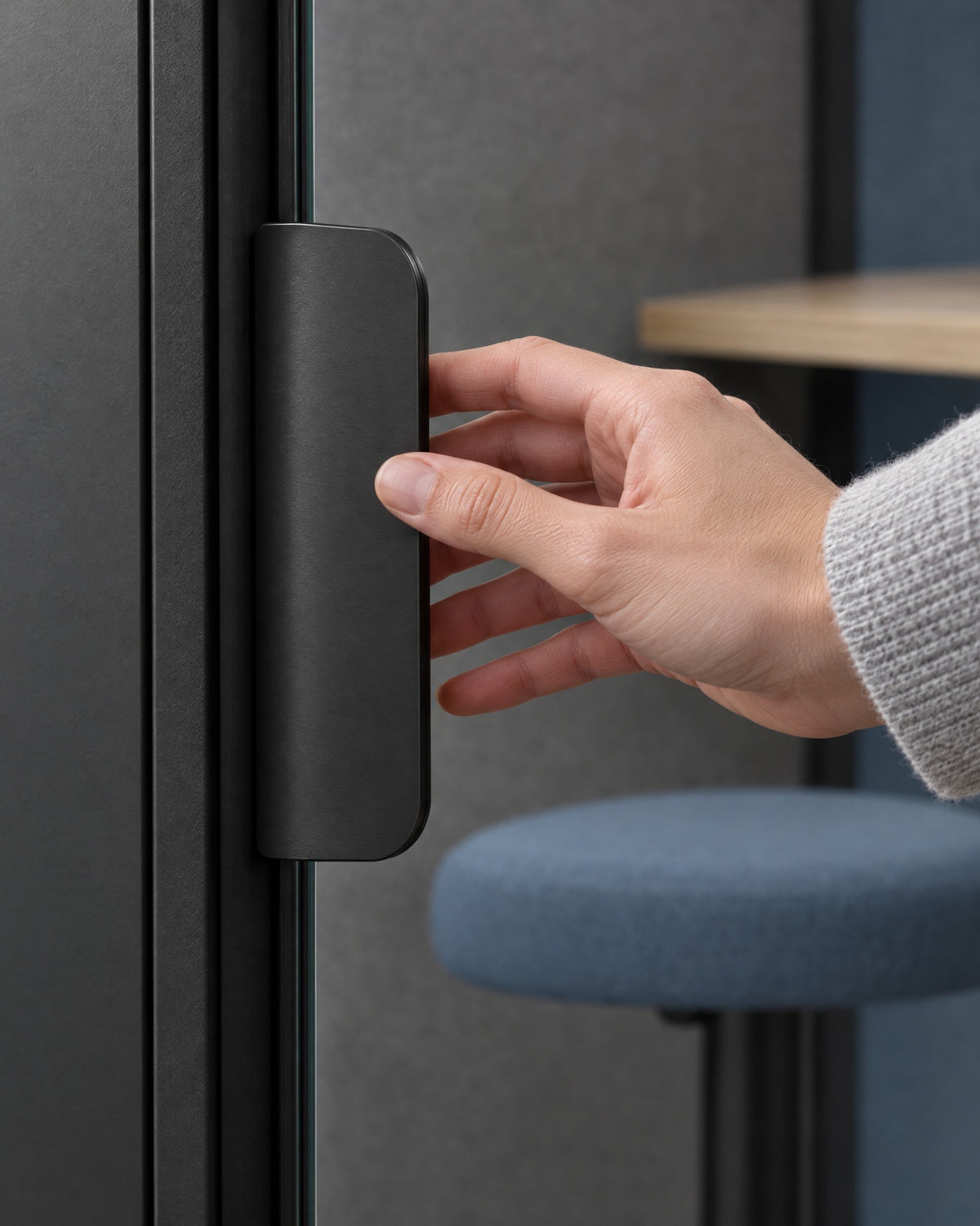 Hand reaching for the flat dark satin door pull of a SoundBox VRS Single. Illustration.