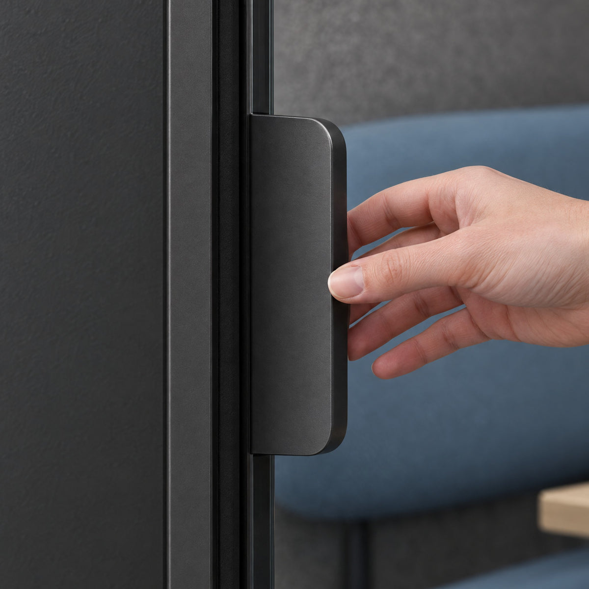 Hand opening the glass door of a SoundBox VRS Single Comfort by its flat dark satin pull. Illustration.