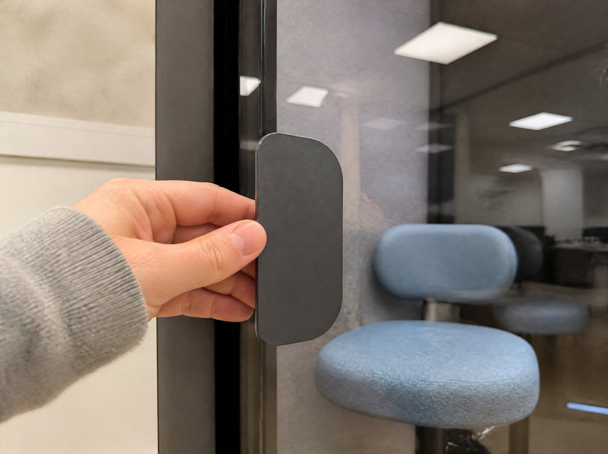 Glass door edge, black frame and handle of a SoundBox VRS pod