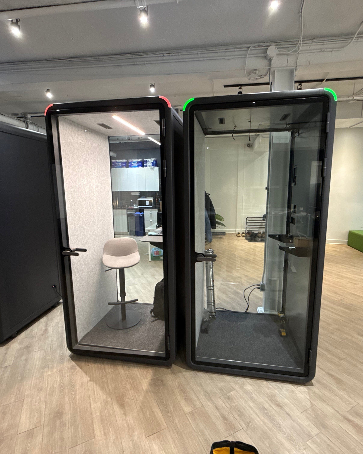 Two Single Work Booths on an open office floor, set back from the lounge seating ::real