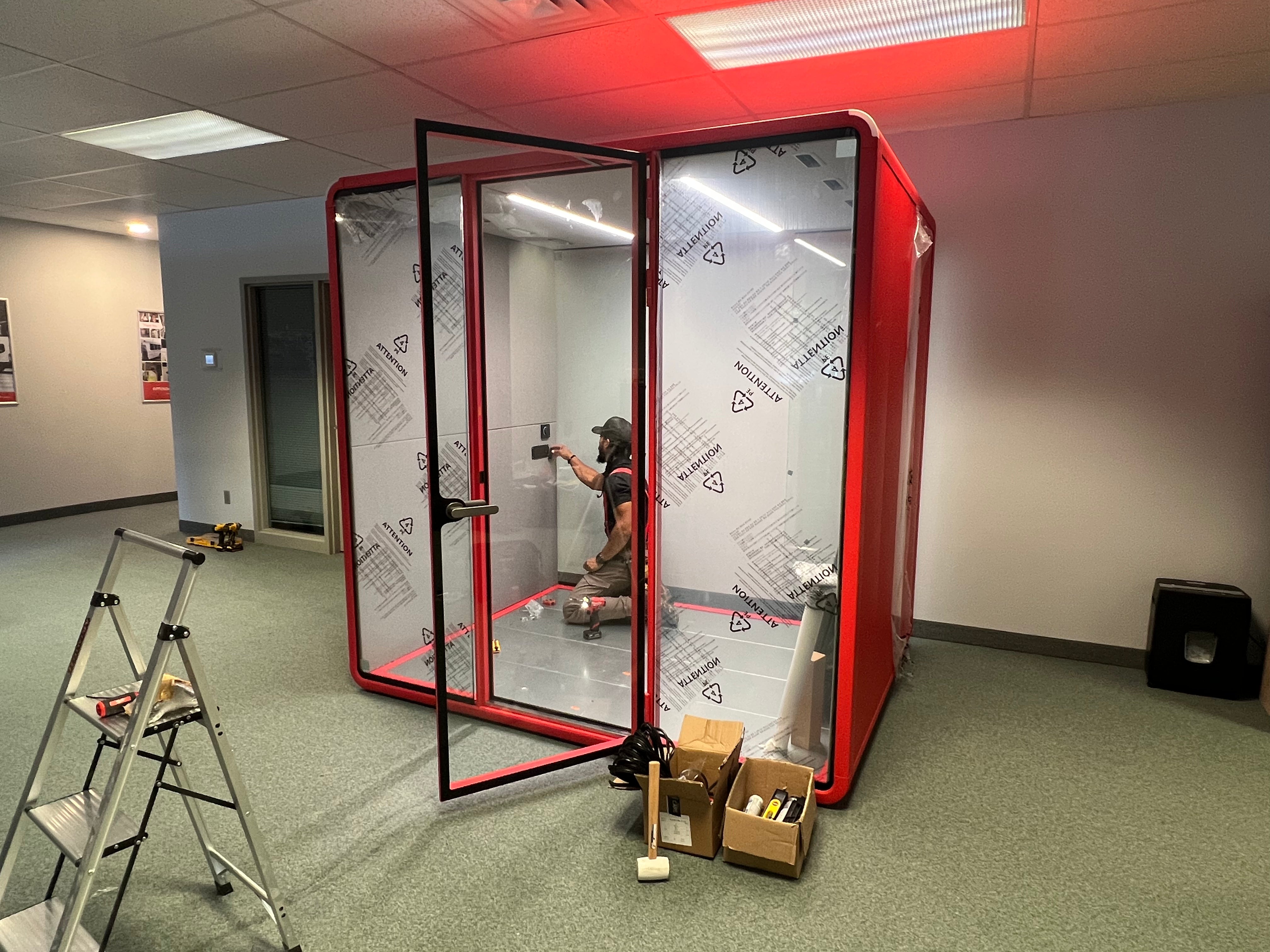 Glass and acoustic panels go in, then power, lighting, and ventilation are connected.