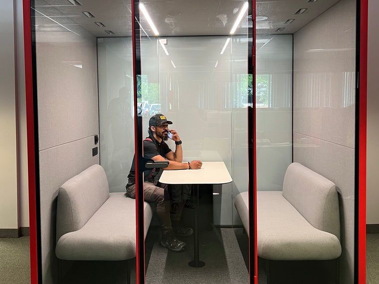 A man taking a phone call inside a closed Quiet Cabins room