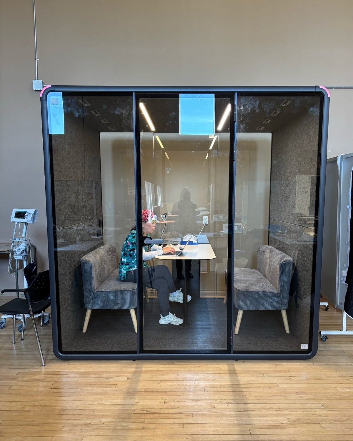 A CMHA staff member working inside a Quiet Cabins Collaborative booth in Oshawa
