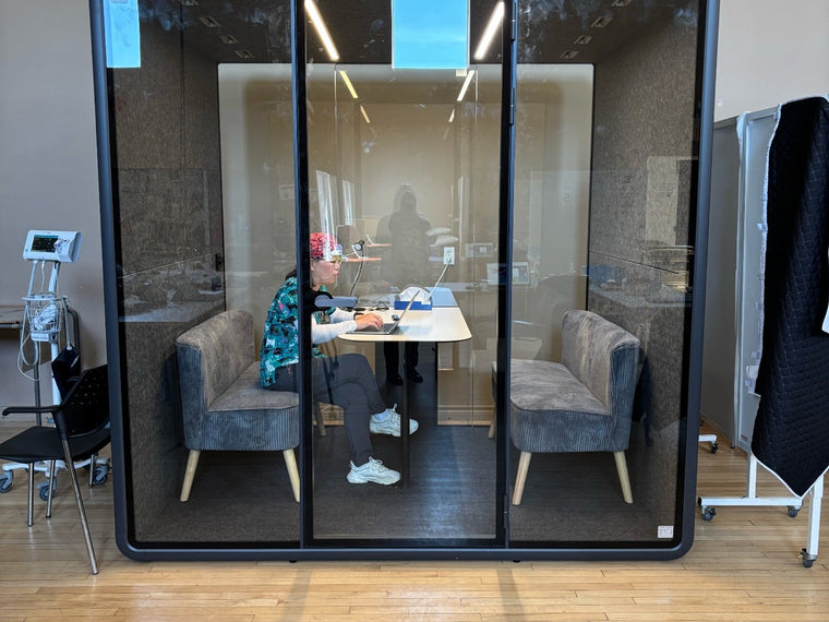 A Quiet Cabins room with its door open in a bright office with city windows