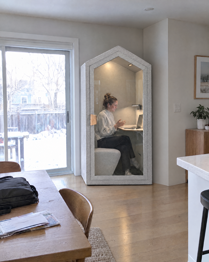 Home Pod against the wall beside snowy patio doors in a townhouse, a woman on a video call inside. Illustration.