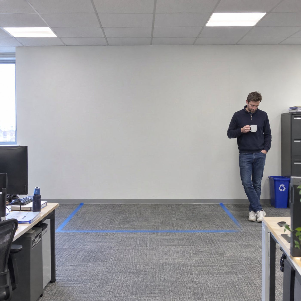 The same spot before delivery: blue painter tape on the carpet marks the 87 by 65 inch footprint