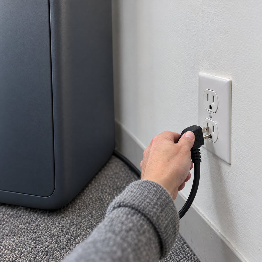 A hand plugging the pod power cord into a standard wall outlet