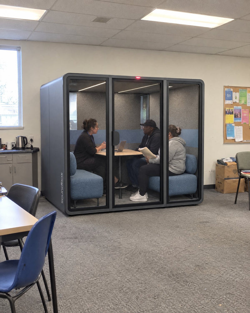 Soundbox VRS Collaborative in a community services office, a caseworker meeting two clients inside