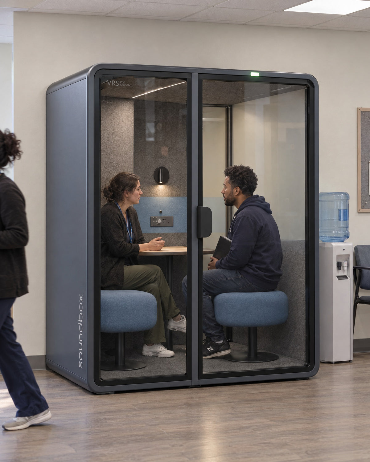 SoundBox VRS Comfort in a community mental health clinic staff area, two people in a private conversation inside. Illustration.