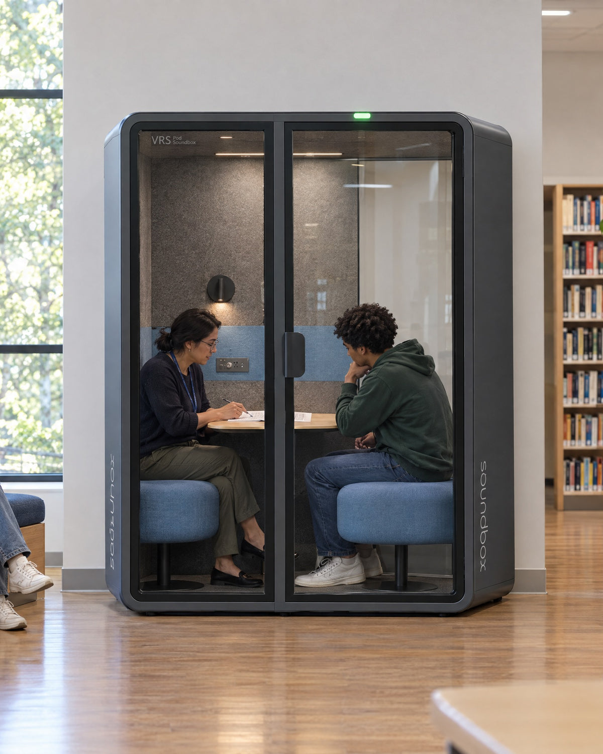 SoundBox VRS Comfort in a university student services office, an advisor and a student meeting inside. Illustration.