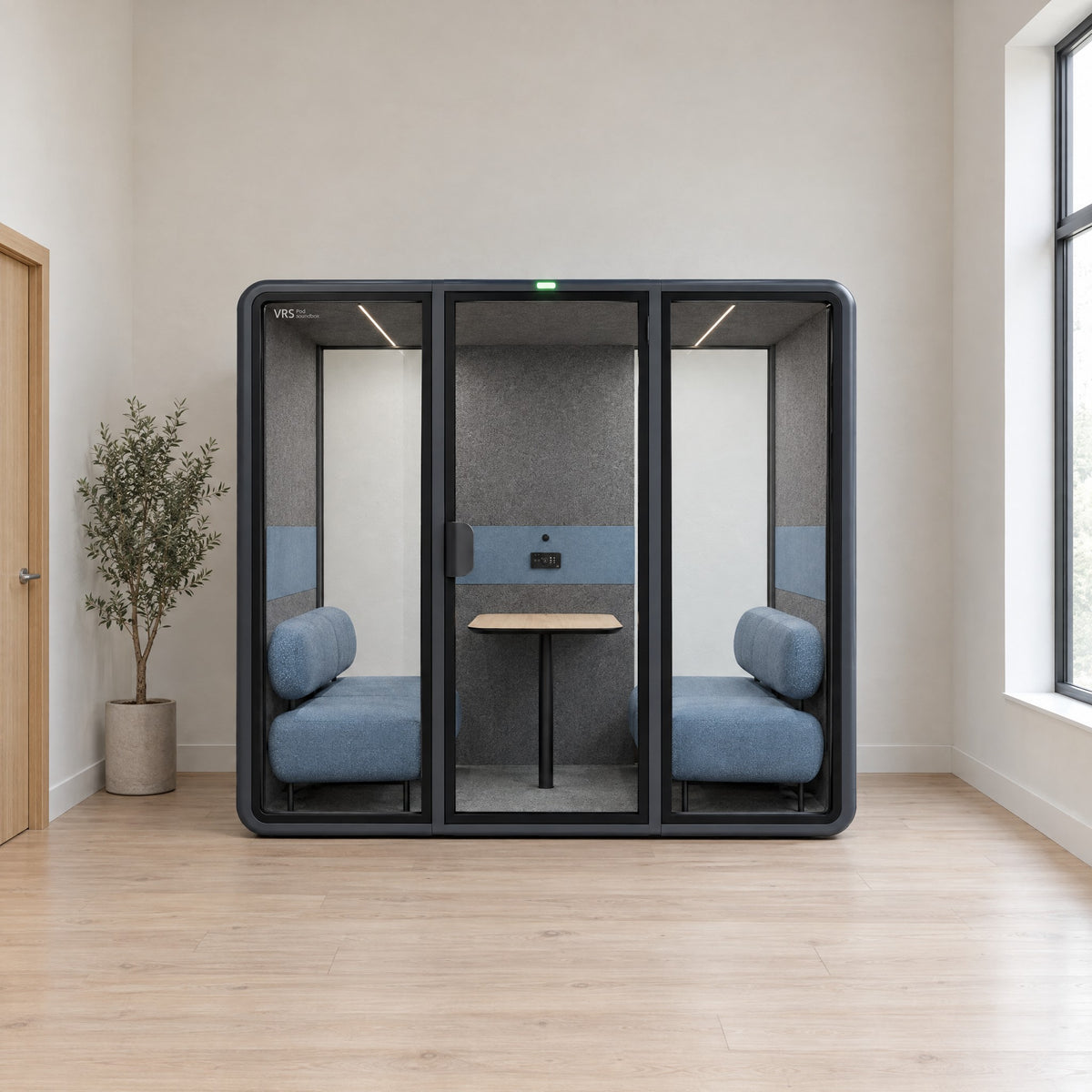 SoundBox VRS Double in a bright clinic staff area, door closed, green available light on, wide clear glass panels at both ends of the back wall. Illustration.