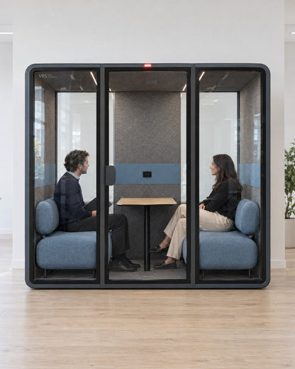 Two people in a private conversation inside a SoundBox VRS Double in an open office, red occupied light on. Illustration.