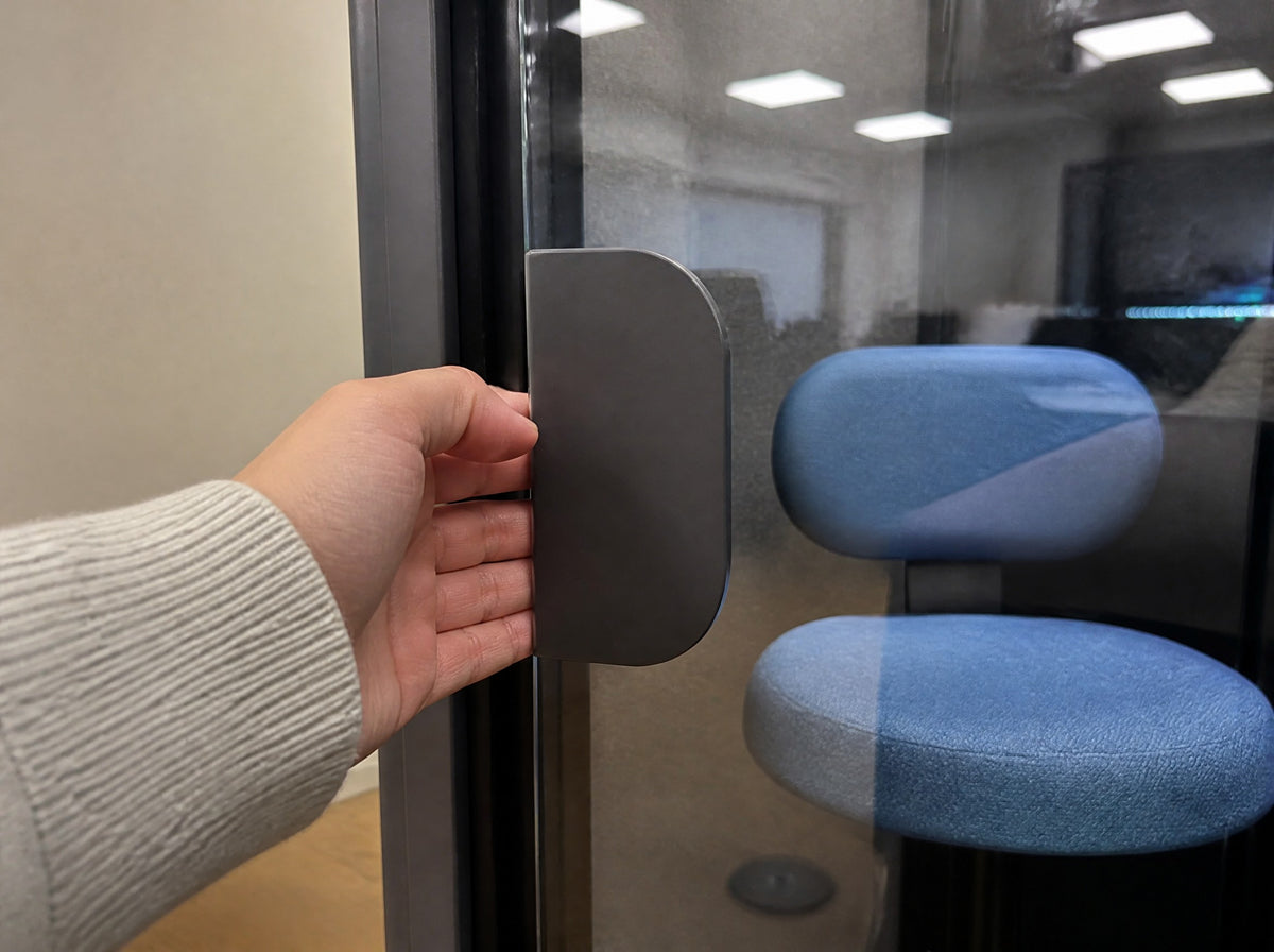 Hand on the flat paddle handle of a SoundBox VRS glass door