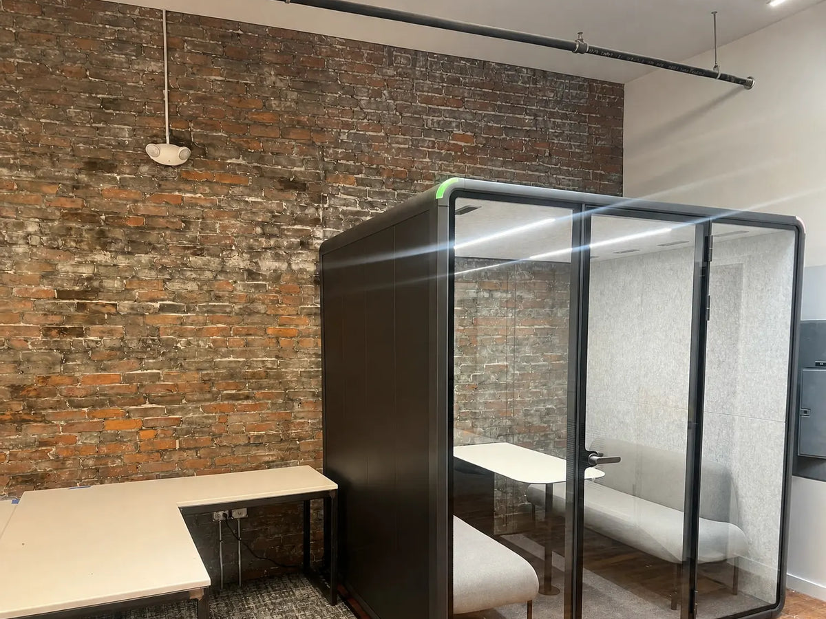 A Collaborative Booth on the floor of a brick-walled creative office