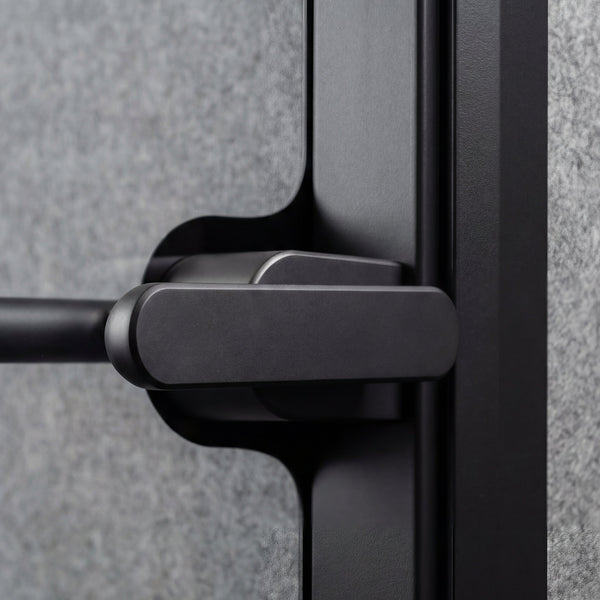 Close-up of the door handle and tempered glass edge on a Quiet Cabins booth