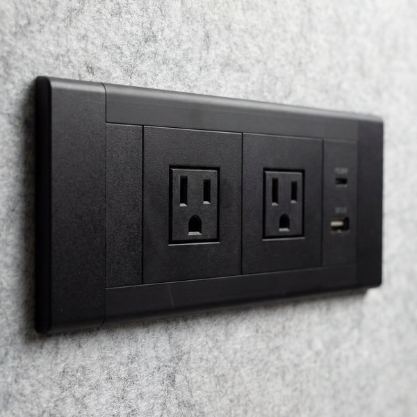 Two universal power sockets plus USB-A and USB-C built into the acoustic wall of a Quiet Cabins booth