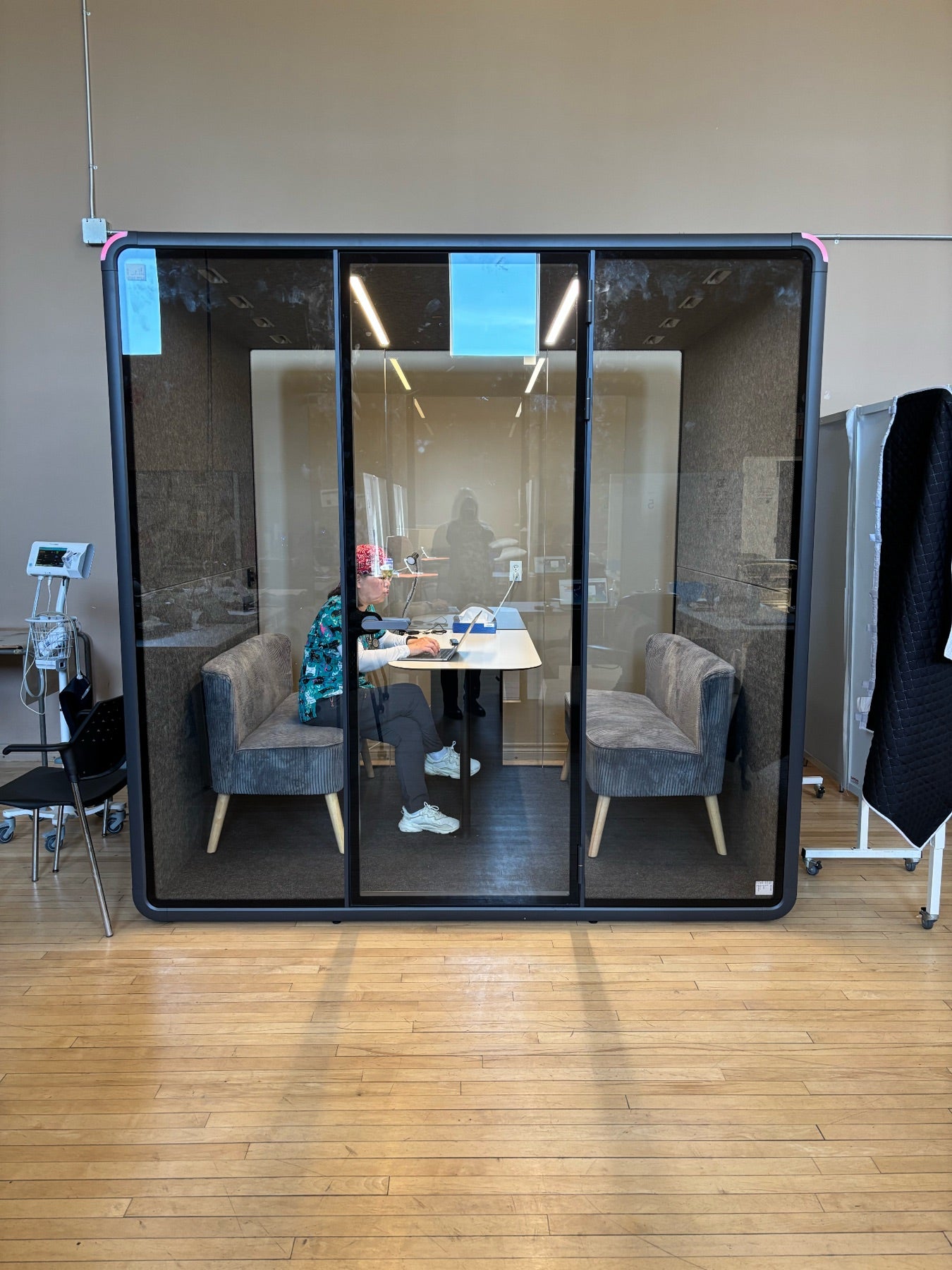 A CMHA staff member working inside a Quiet Cabins Collaborative booth at the Yes Collaborative site in Oshawa